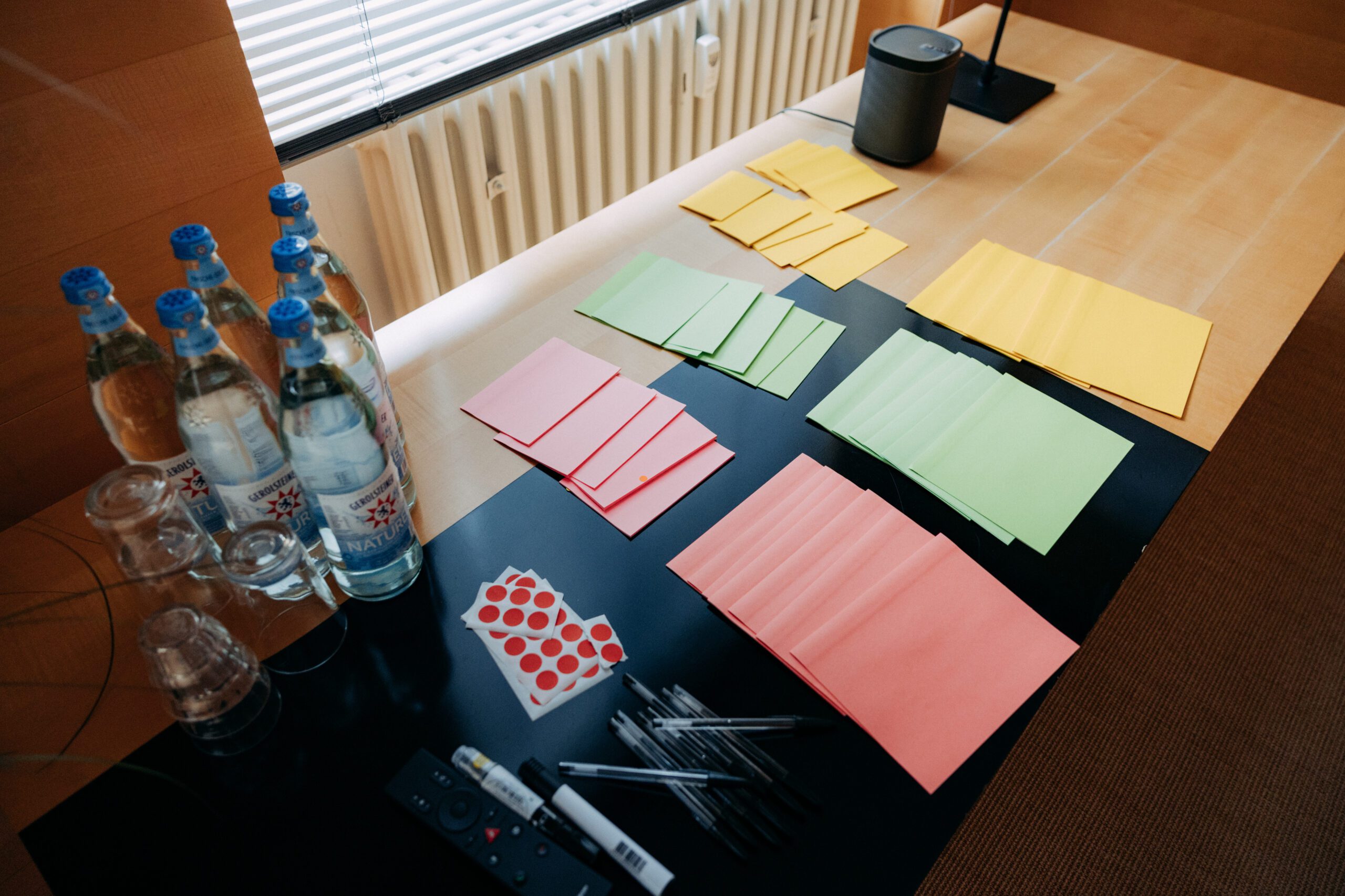 Man sieht Sticky Notes sowie ein Blatt mit QR-Codes auf einem Tisch aus der Vogelperspektive.