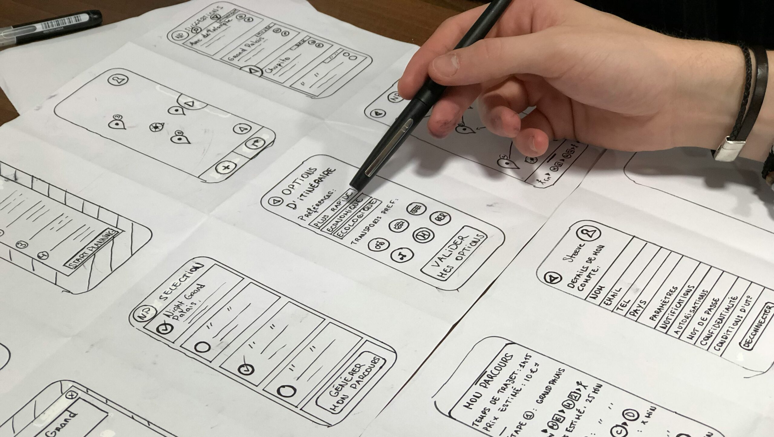 Man sieht mehrere Entwürfe für UI-Designs auf einem Blatt Papier.